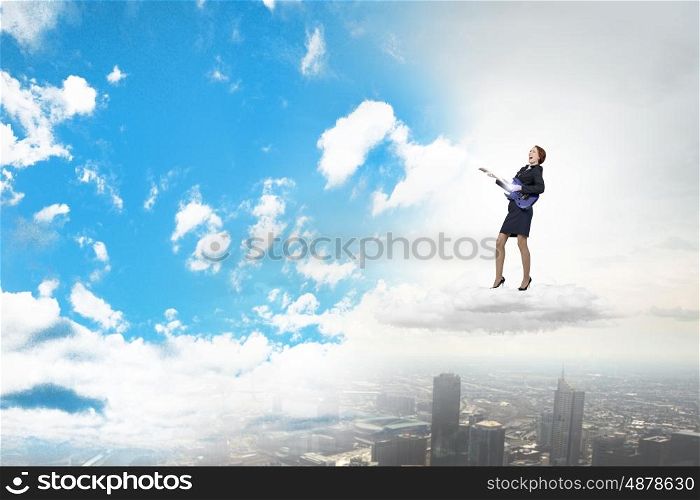 Cheerful businesswoman on cloud playing electronic guitar. Playing melody of success