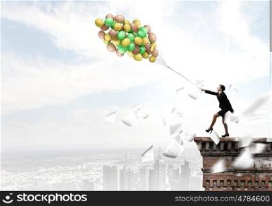Cheerful businesswoman. Young joyful businesswoman walking with bunch of colorful balloons