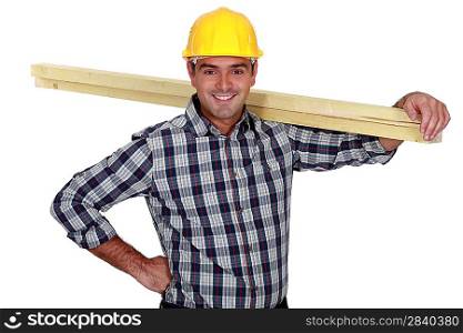 Cheerful carpenter carrying timber