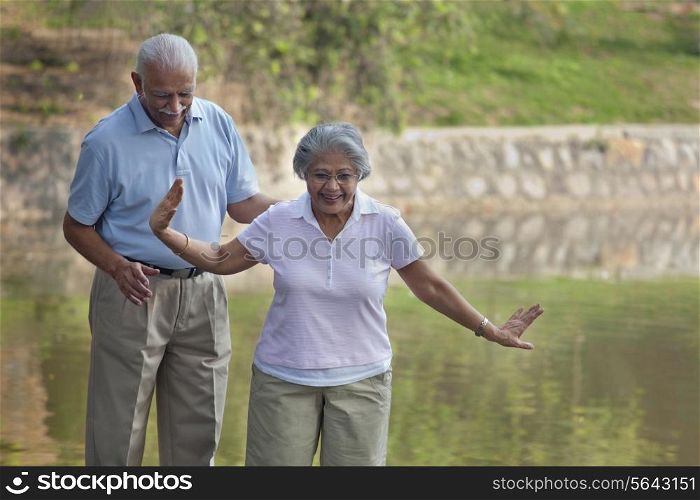 Cheerful casually dressed couple walking in park