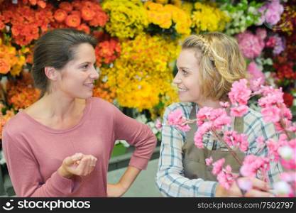 cheerful charming young woman florist with customer