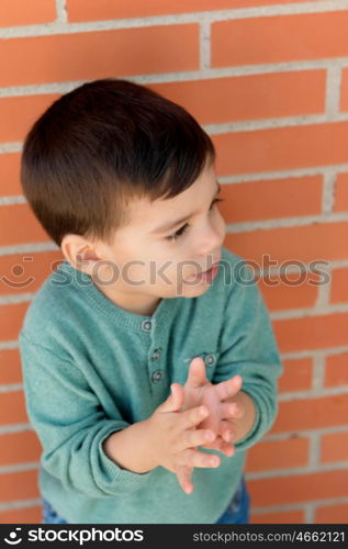 Cheerful child playing palms on the street