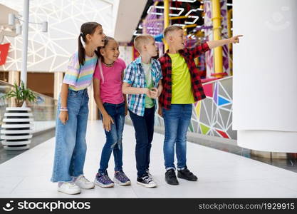 Cheerful children walking in entertainment center. Boys and girls having fun, kids spend the weekend on playground, happy childhood. Cheerful children walking in entertainment center