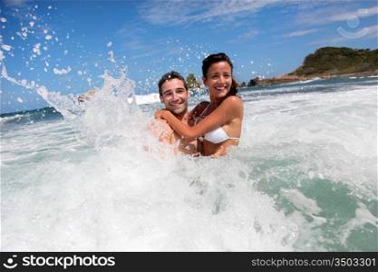 Cheerful couple enjoying the waves