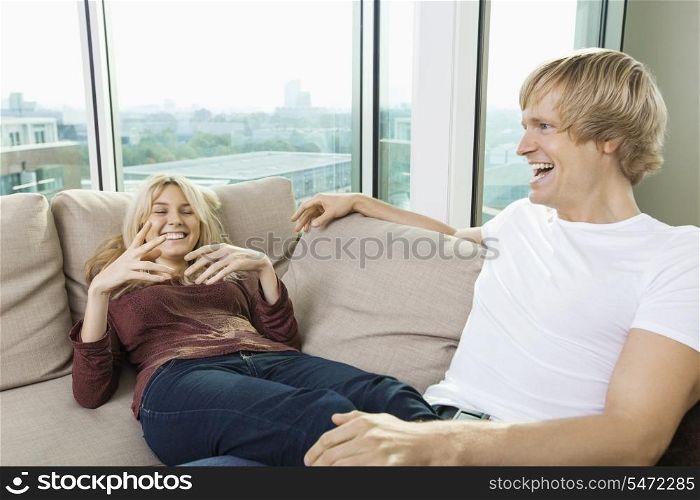 Cheerful couple relaxing on sofa at home