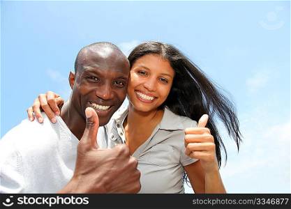 Cheerful couple showing thumbs up