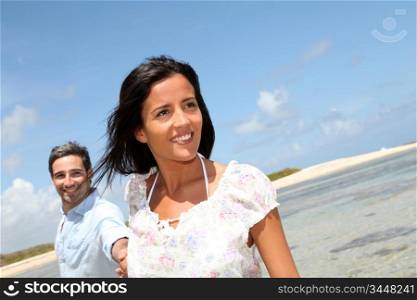 Cheerful couple walking by the sea