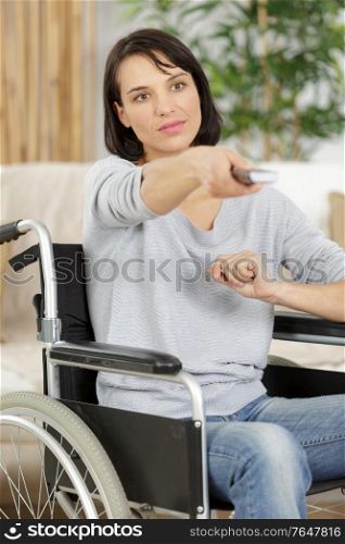 cheerful disabled senior woman watching television in living room