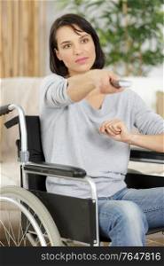 cheerful disabled senior woman watching television in living room