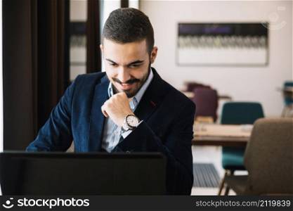 cheerful elegant man using laptop