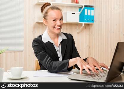cheerful emotional woman office worker holding his fingers on laptop keyboard