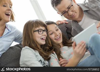 Cheerful family using tablet PC at home