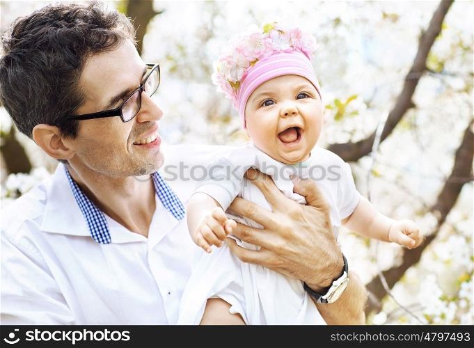 Cheerful father holding his beloved baby