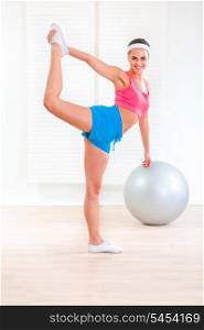 Cheerful fitness young girl doing stretching exercises at living room&#xA;