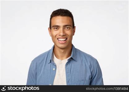 Cheerful, friendly handsome young tanned man in blue shirt over t-shirt, laughing, smiling happy as looking camera with enthusiastic, amused expression, promote something funny and joyful.. Cheerful, friendly handsome young tanned man in blue shirt over t-shirt, laughing, smiling happy as looking camera with enthusiastic, amused expression, promote something funny and joyful