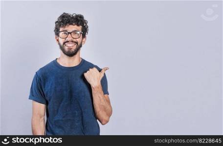 Cheerful friendly man showing you the direction to a nice place, friendly person pointing thumb to the right, smiling people pointing to the right on isolated background