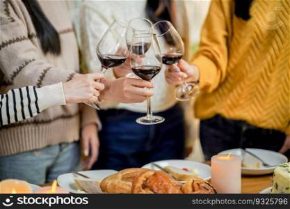 Cheerful friends enjoying home Birthday holiday party. Asian Friends cheering drinking red wine celebrating Christmas or New Year party.