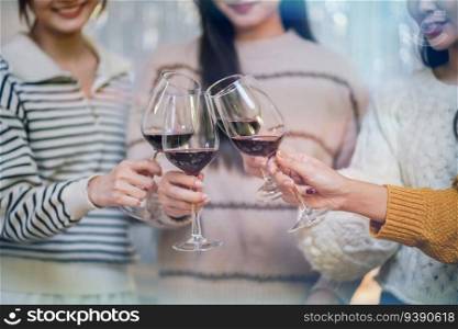 Cheerful friends enjoying home Birthday holiday party. Asian Friends cheering drinking red wine celebrating Christmas or New Year party.