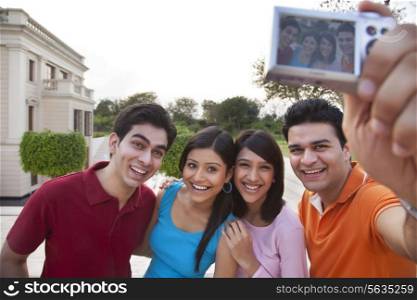 Cheerful friends taking selfie outdoors