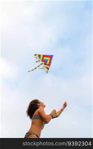 Cheerful girl flies a kite on the beach. Enjoying active games outdoors. Beach activities. Happy summer holidays.. Activities for kids on the beach