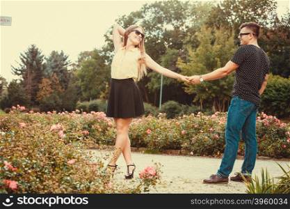 Cheerful girl holding hands in park. . Love romance relationship dating concept. Cheerful girl holding hands in park. Young girl and boy taking walk.