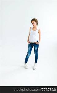 cheerful girl in a white t-shirt and dark blue jeans in the studio on a white background stands, sits, runs