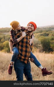 Cheerful guy and girl on a walk in bright knitted hats and plaid shirts