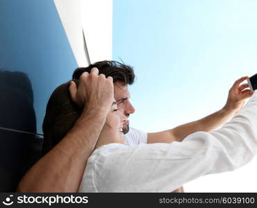 cheerful happy young couple making selfie together at home