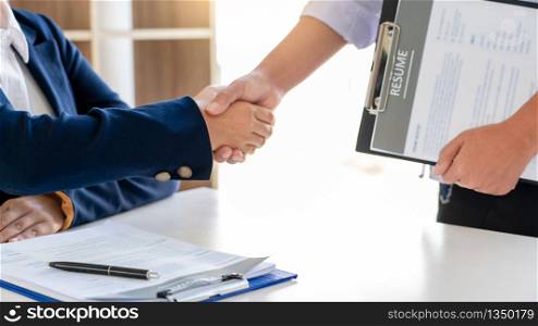 Cheerful interviewer hr manager welcoming women applicant at job interview handshaking at group meeting talk and effective negotiation