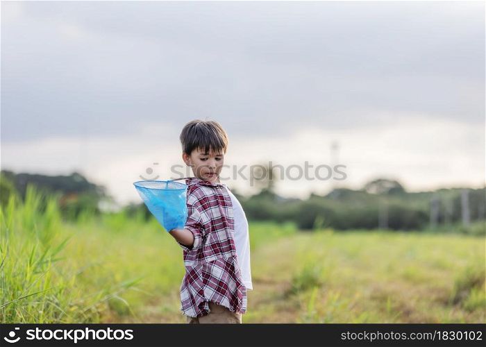 Cheerful kids playing in a field With Insect Net at outdoor in summer
