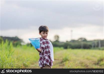 Cheerful kids playing in a field With Insect Net at outdoor in summer