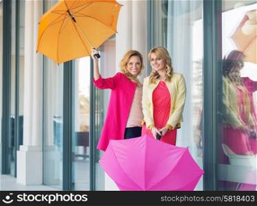 Cheerful ladies posing with the colorful umbrellas