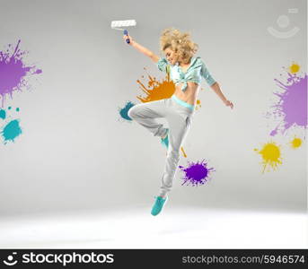 Cheerful lady holding a paint roller