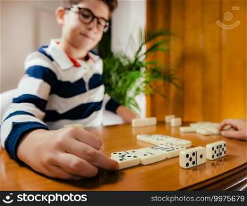 Cheerful little boy playing dominoes.