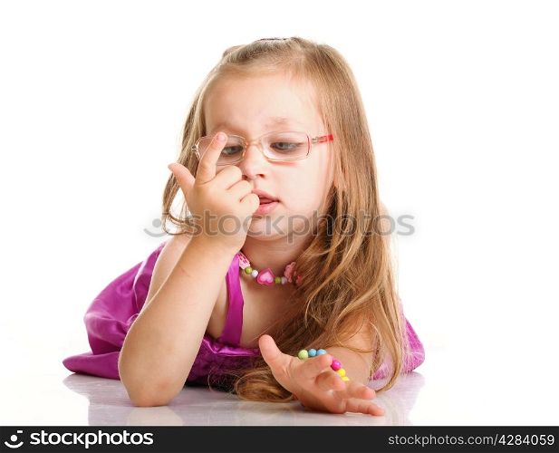 cheerful little girl glasses to count funny is lying isolated on the white background