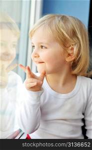 cheerful little girl sits at window portrait