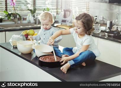 Cheerful, little siblings making a dessert
