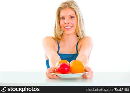 Cheerful lovely young girl sitting at table with plate of fruits&#xA;