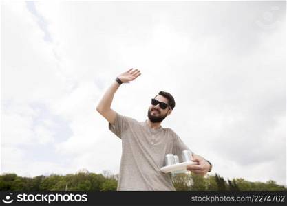 cheerful male with drinks waving hand