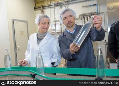 cheerful man and woman working in a brewery factory