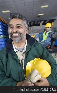 Cheerful man standing in factory