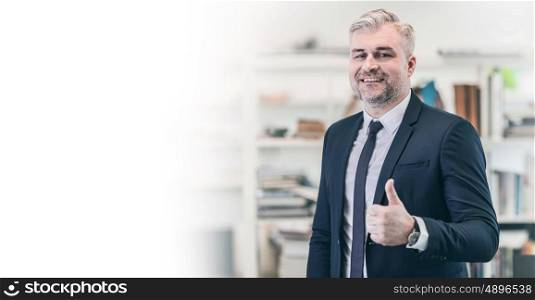 Cheerful mature businessman thumbs up posing and smiling at camera in office, white copy space