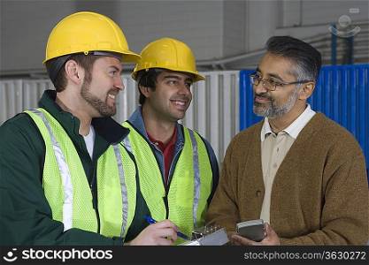 Cheerful men talking in factory