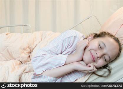 Cheerful mixed race Asian American tween girl in hospital bed