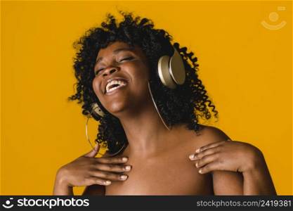 cheerful naked ethnic young woman earphones studio