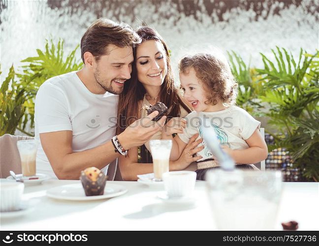 Cheerful parents feeding their beloved daughter