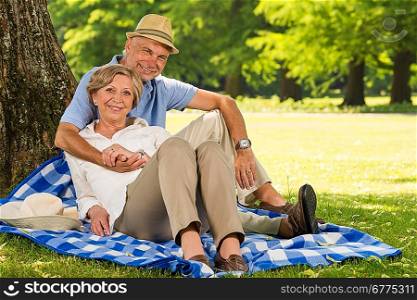Cheerful pensioners hugging and relaxing outdoors sunny park