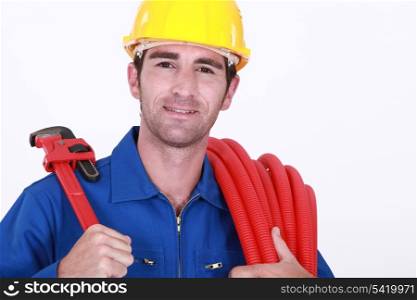 Cheerful plumber carrying hose