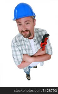 Cheerful plumber holding adjustable wrench