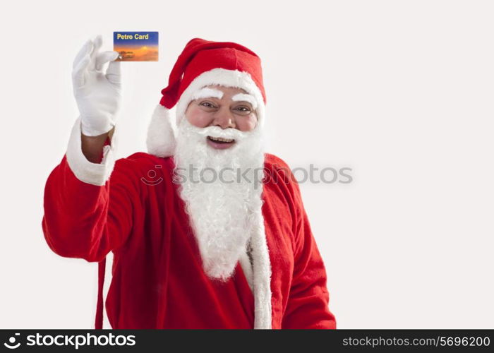 Cheerful Santa Claus showing petro card over colored background